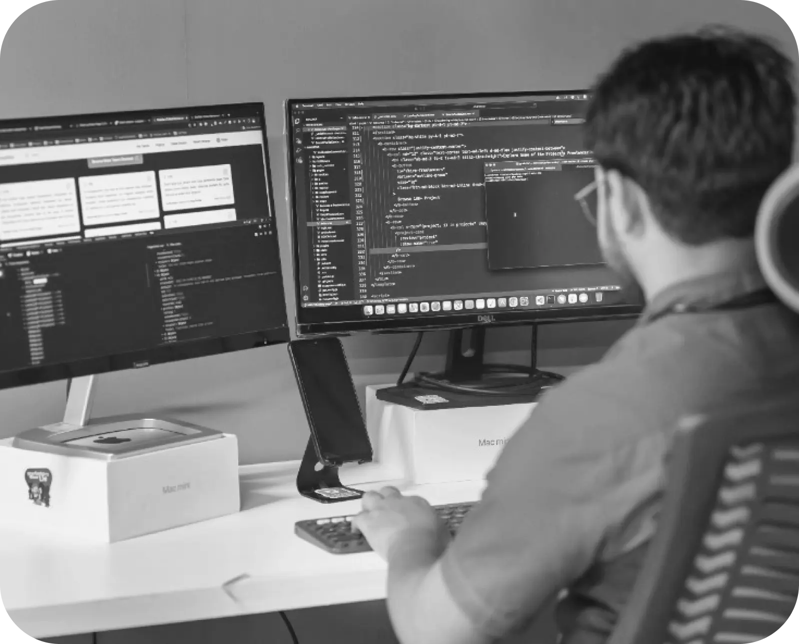 a man sitting at a computer typing code